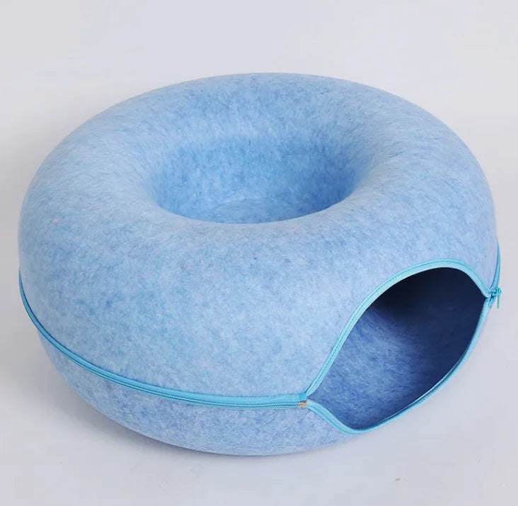 Blue pet bed with a donut shape on a light gray background