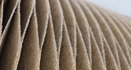 Close-up of pleated brown paper with a blurred background