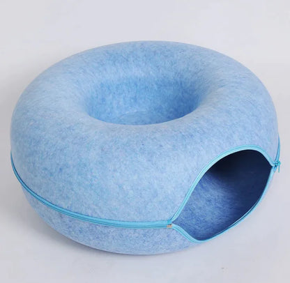 Blue pet bed with a donut shape on a light gray background